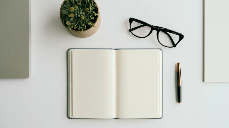 Top-down view of a tidy desk with an open notebook, reading glasses and a small potted plant